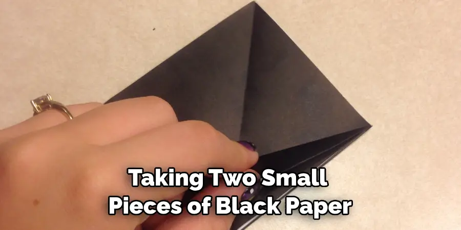 Taking Two Small Pieces of Black Paper