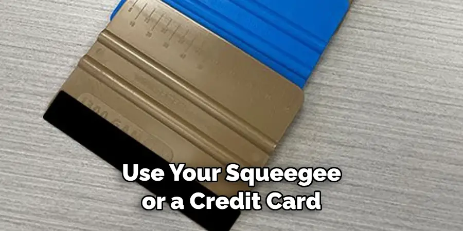 Use Your Squeegee or a Credit Card 