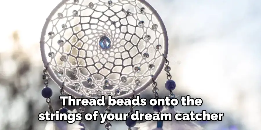 Thread beads onto the strings of your dream catcher