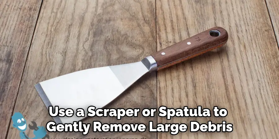 Use a Scraper or Spatula to Gently Remove Large Debris